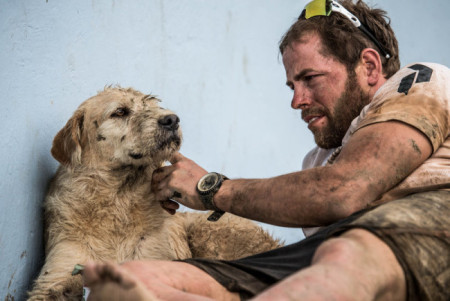 Swedish endurance athlete Mikael Lindnord gives Arthur an affectionate scratch of approval. Photo Credit: Krister Goransson