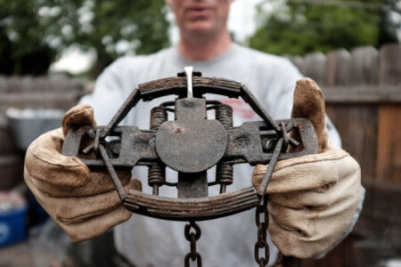 Jim Horton, a licensed animal trapper in Westchester County, with a foothold he uses on coyotes. Photo Credit: Andrew Sullivan for The New York Times
